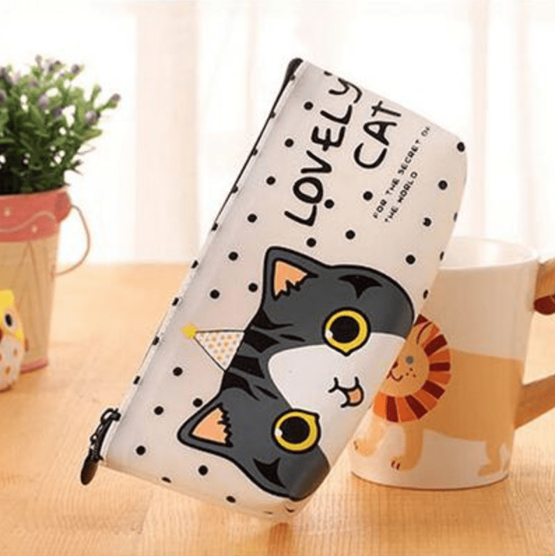 cat themed pencil case next to cup