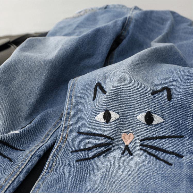 Jeans with shop cats on knees