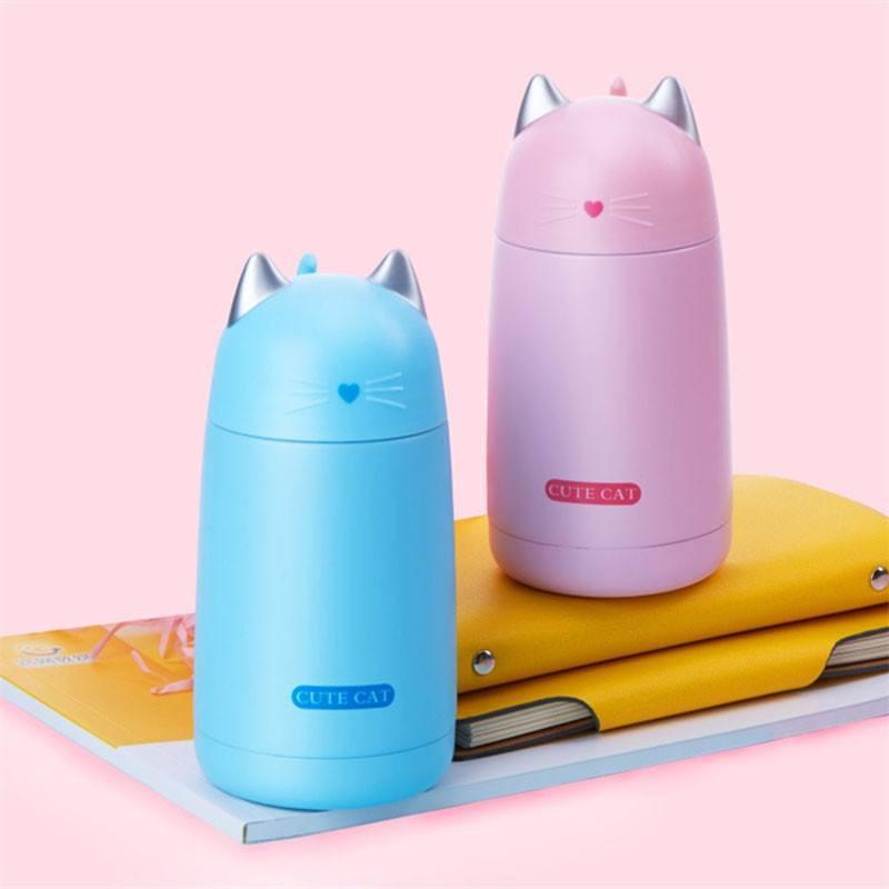 pink and blue cat thermos on books and folder