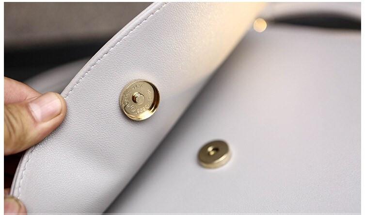 Side View of Cat Moon Leather Handbag Showing button lock - White on Desk